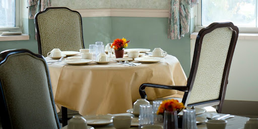 An elegant dining table set with fine china and a colorful floral arrangement, ready for guests.