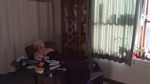 An elderly patient resting in a hospital room with natural light streaming in through the window.