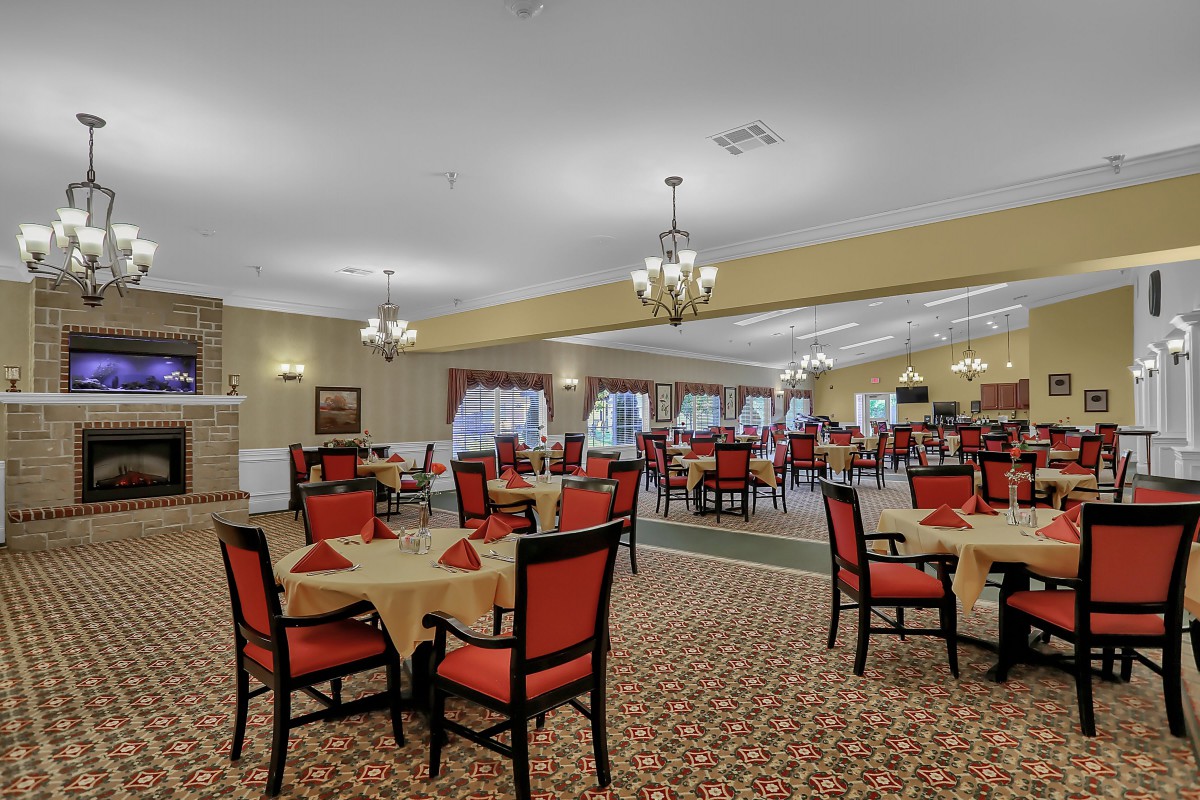 An elegant dining room with red chairs and round tables set in an inviting atmosphere.