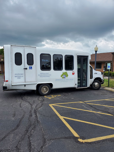 A white accessible bus parked in a lot under a cloudy sky.