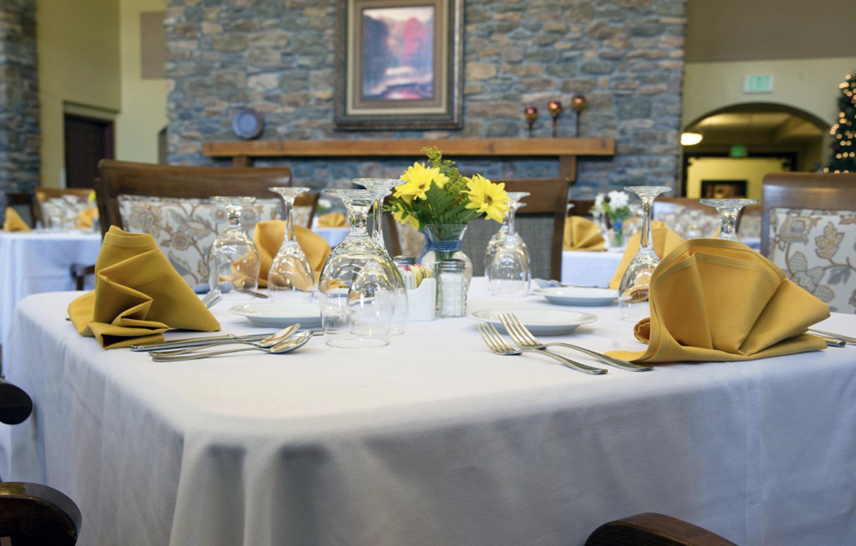 A beautifully set dining table adorned with floral centerpieces and fine glassware.
