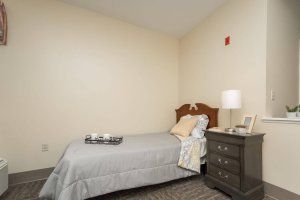 A minimalist bedroom with a single bed and a nightstand.