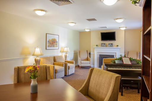 A cozy living room featuring comfortable chairs, a dining table, and warm lighting.