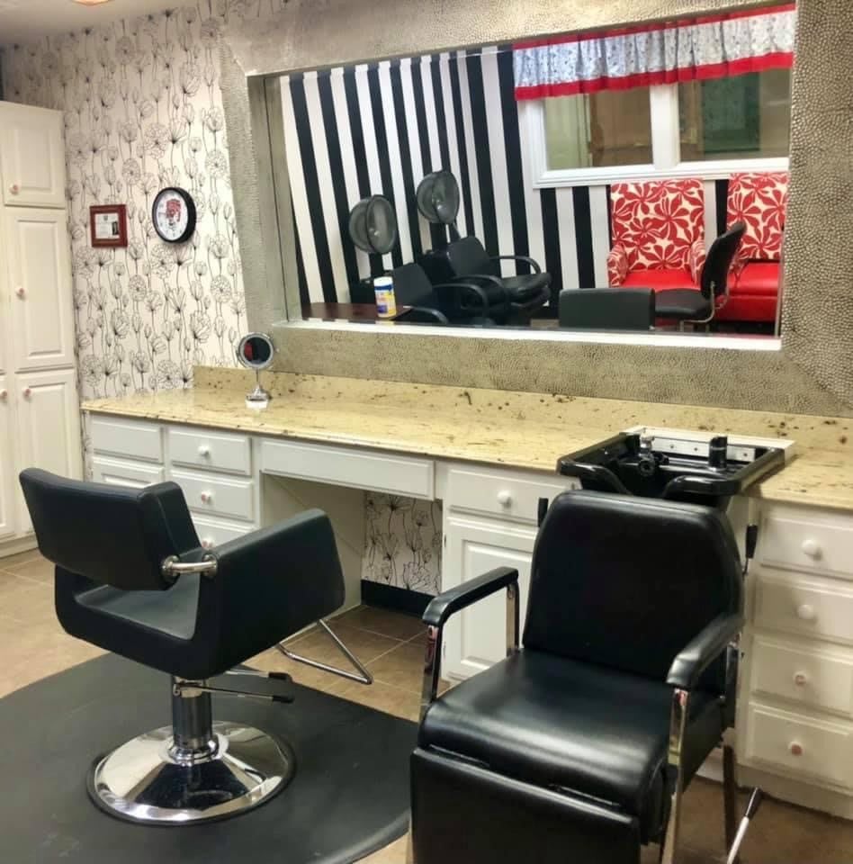 A well-kept hair salon interior with modern barber chairs and a large mirror.