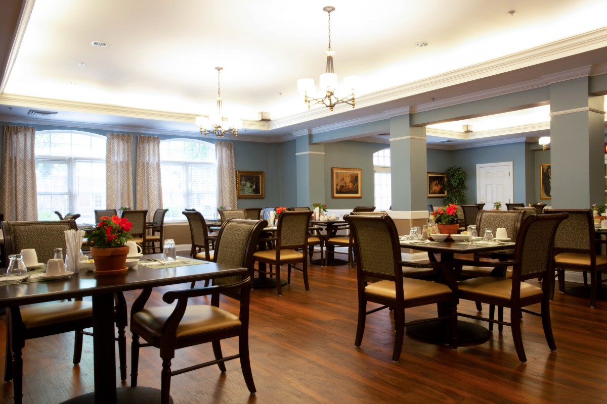 A well-lit dining area with elegantly arranged tables and chairs.