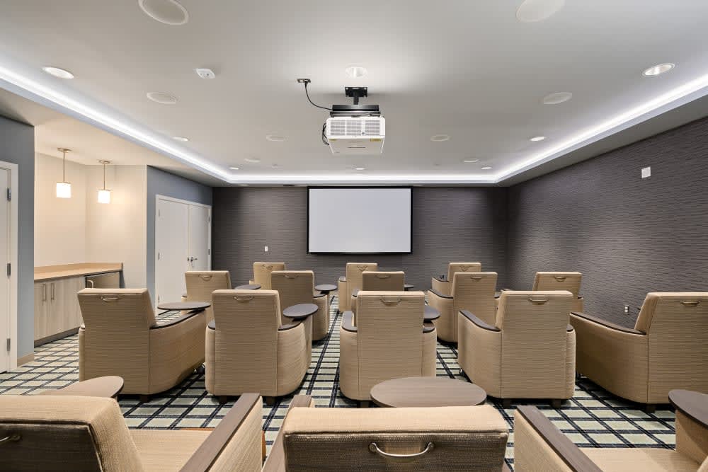 A modern home theater with comfortable recliner seating and a large projector screen.
