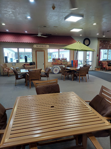 A spacious lounge area featuring wooden furniture and ample seating, designed for relaxation and socializing.