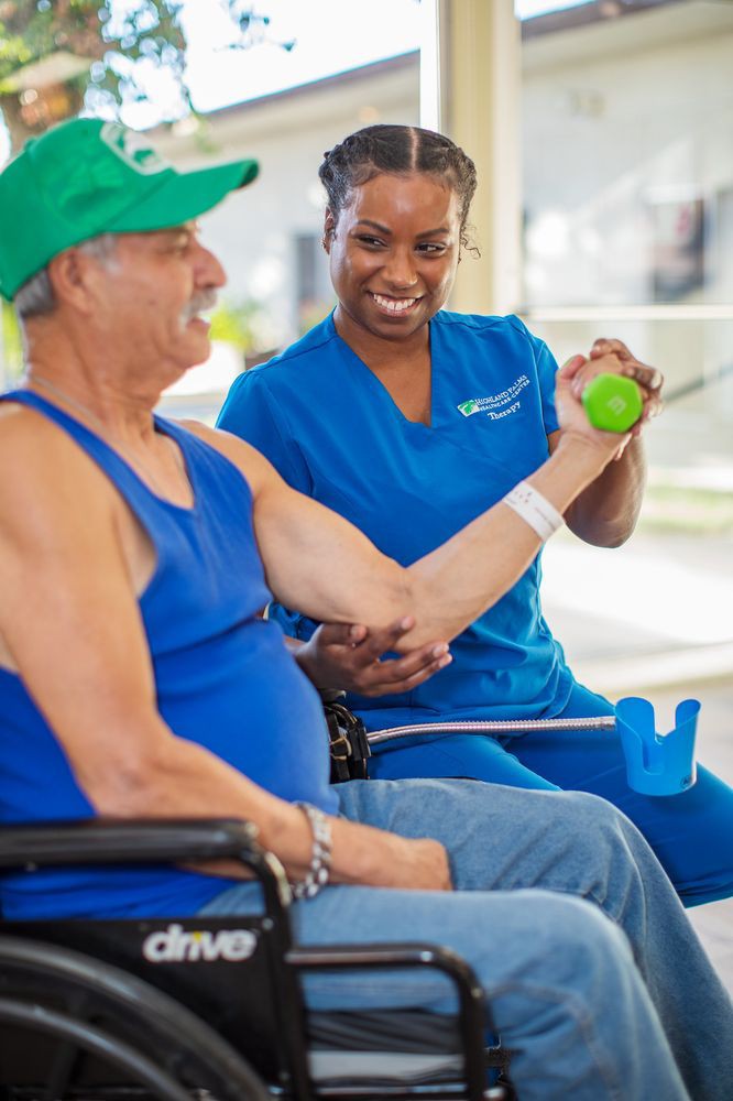 A therapist assists a patient with arm exercises during a physical therapy session.