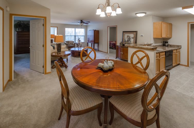 A cozy dining and living area with a wooden table, chairs, and modern lighting.