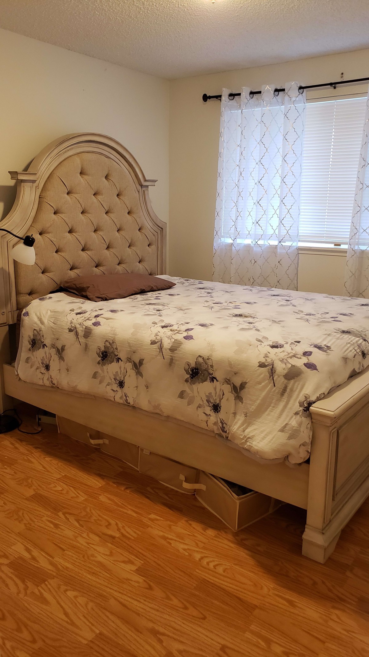 A well-furnished bedroom with a stylish bed and floral bedding.