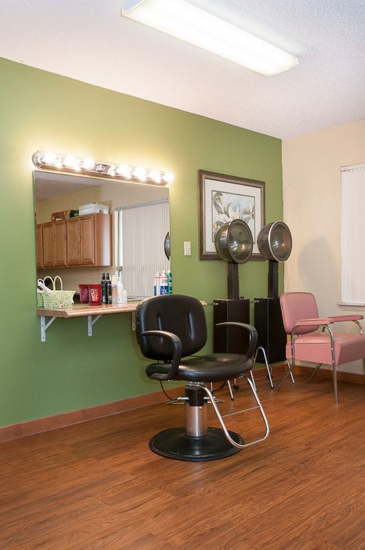 A cozy hair salon interior with styling chairs, a mirror, and salon equipment.
