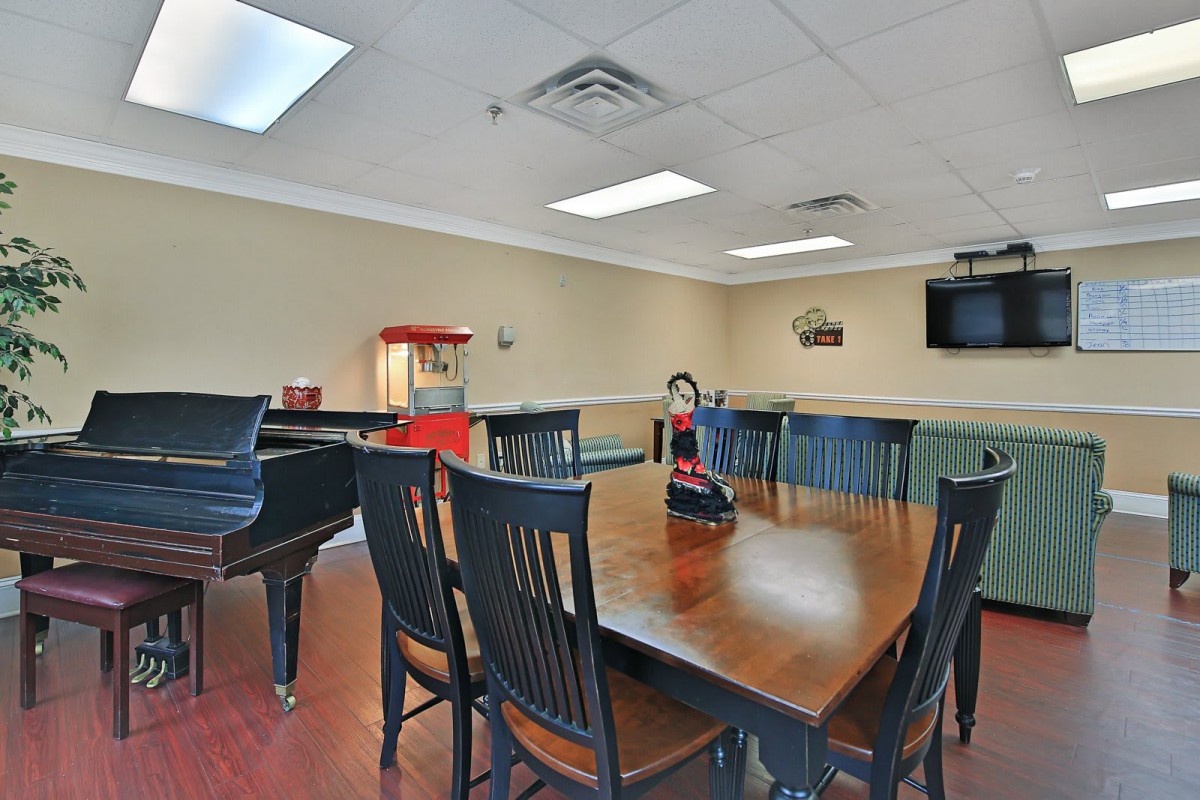 A conference room with a large meeting table, chairs, and a popcorn machine in the corner.