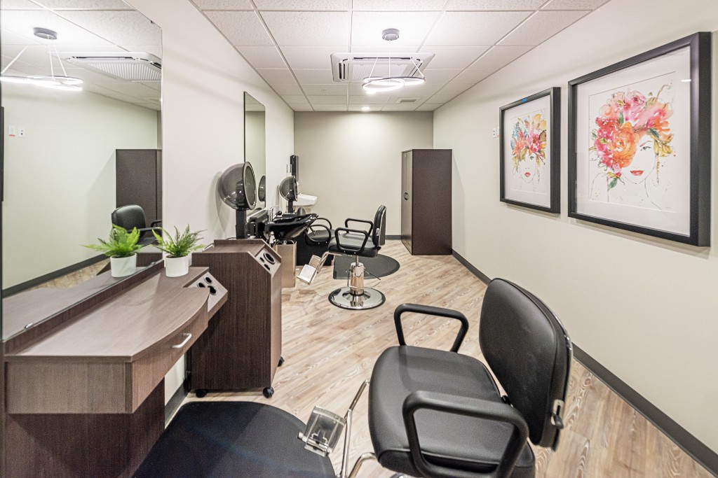A modern hair salon interior with styling chairs and mirrors.