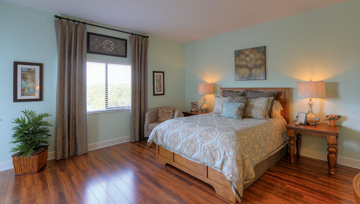 A cozy bedroom with elegant decor and a wooden floor.
