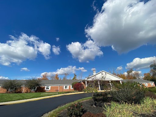 A picturesque building under a bright blue sky adorned with fluffy clouds.
