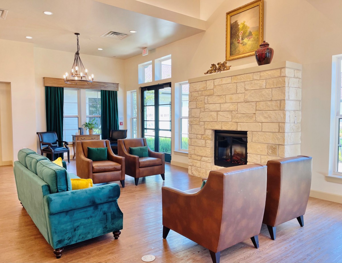 A cozy living room featuring a stone fireplace, comfortable seating, and elegant decor.