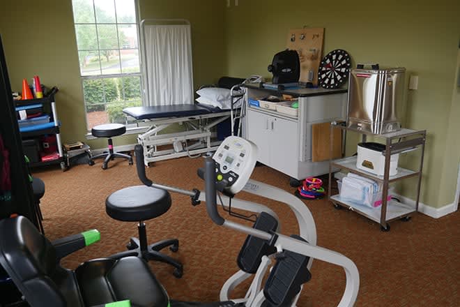 A physical therapy clinic with rehabilitation equipment and treatment tables.