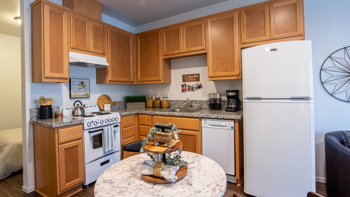 A cozy kitchen with wooden cabinets, modern appliances, and stylish decor.