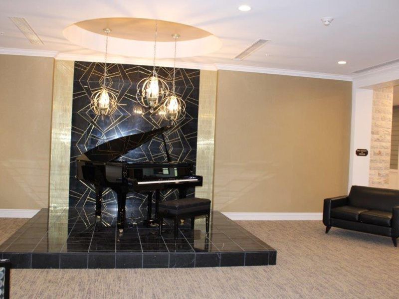A stylish lounge featuring a grand piano with modern lighting.