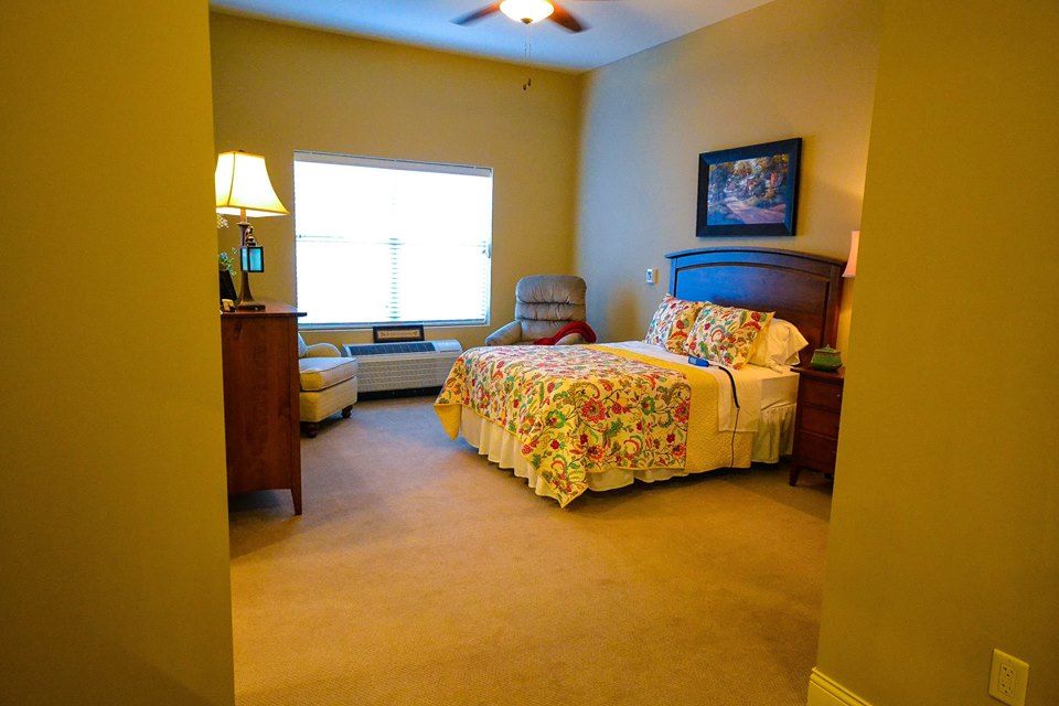 A cozy bedroom with colorful bedding and warm lighting.