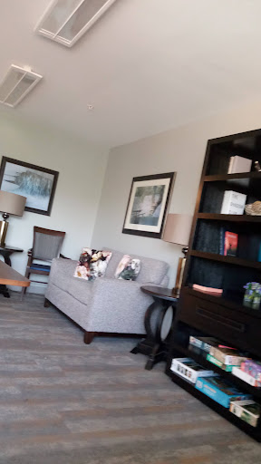 A cozy living room setup featuring a gray couch, decorative shelves, and stylish lamps.