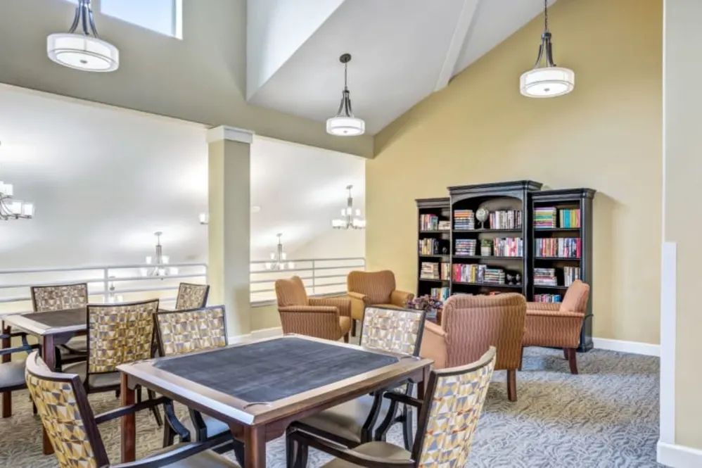 A cozy library area with comfortable seating, bookshelves, and modern decor.