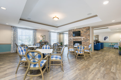 A modern dining area featuring stylish furniture, a stone fireplace, and ample natural light.