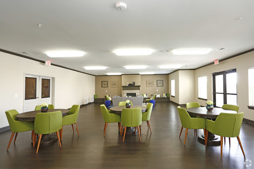 A spacious and modern dining area featuring green chairs and wooden tables.
