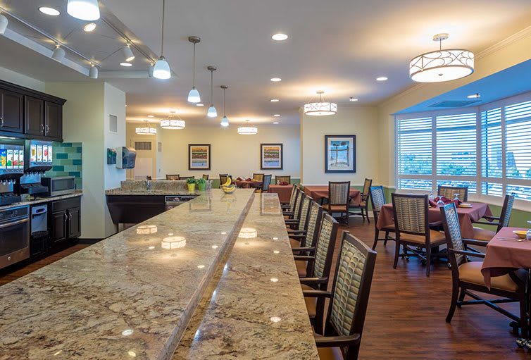 A modern kitchen and dining area with a long countertop and comfortable seating.