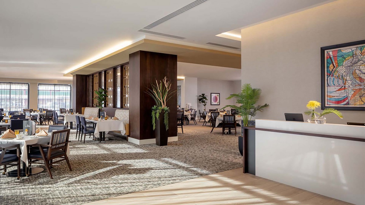A modern and bright hotel lobby with sleek furniture and decorative plants.