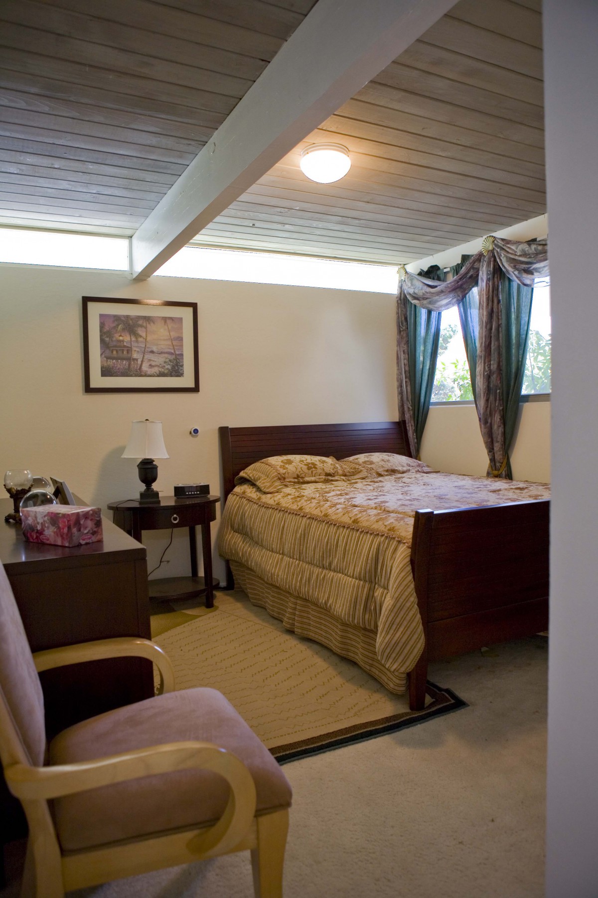 A cozy bedroom with a bed, side tables, and a window with curtains.