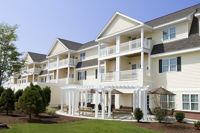 Modern apartment building with balconies and outdoor seating area.