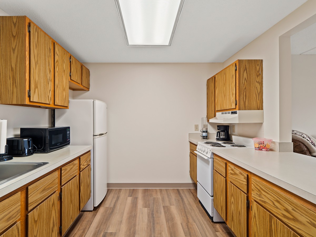A modern kitchen with wooden cabinets and standard appliances.