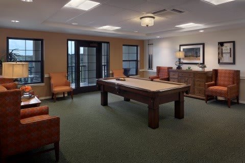 A cozy game room featuring a pool table and comfortable seating.
