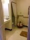 A cozy bathroom featuring a bathtub with a curtain, towel rack, and floor mat.