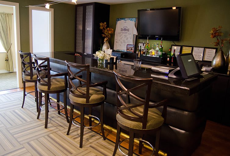 A cozy home bar setup with bar stools, a counter, and a television.