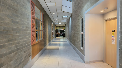 A modern, well-lit hallway featuring sleek walls and flooring.
