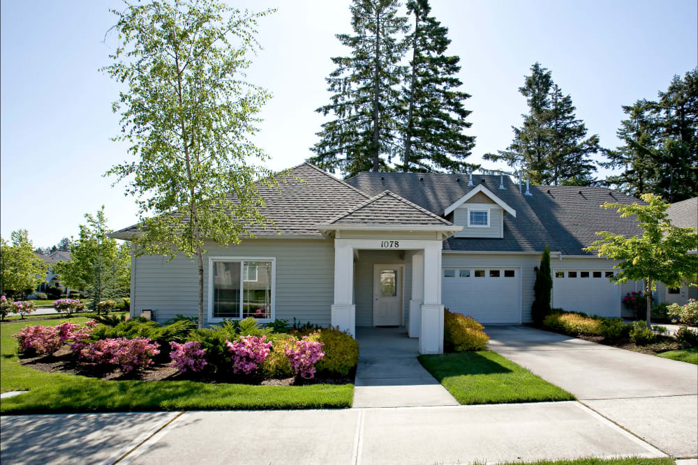 A suburban house with a well-maintained garden and driveway.