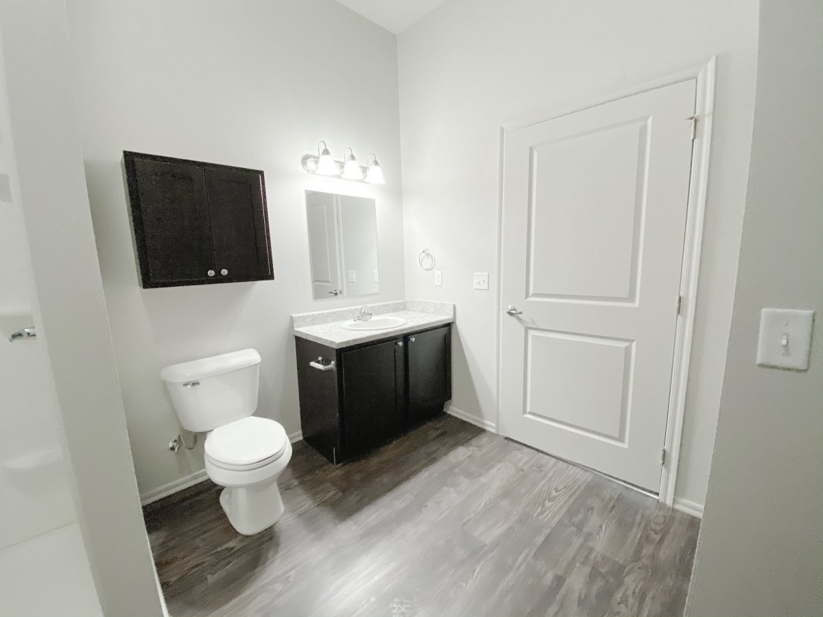 A modern, minimalist bathroom with a toilet, sink, and mirror.
