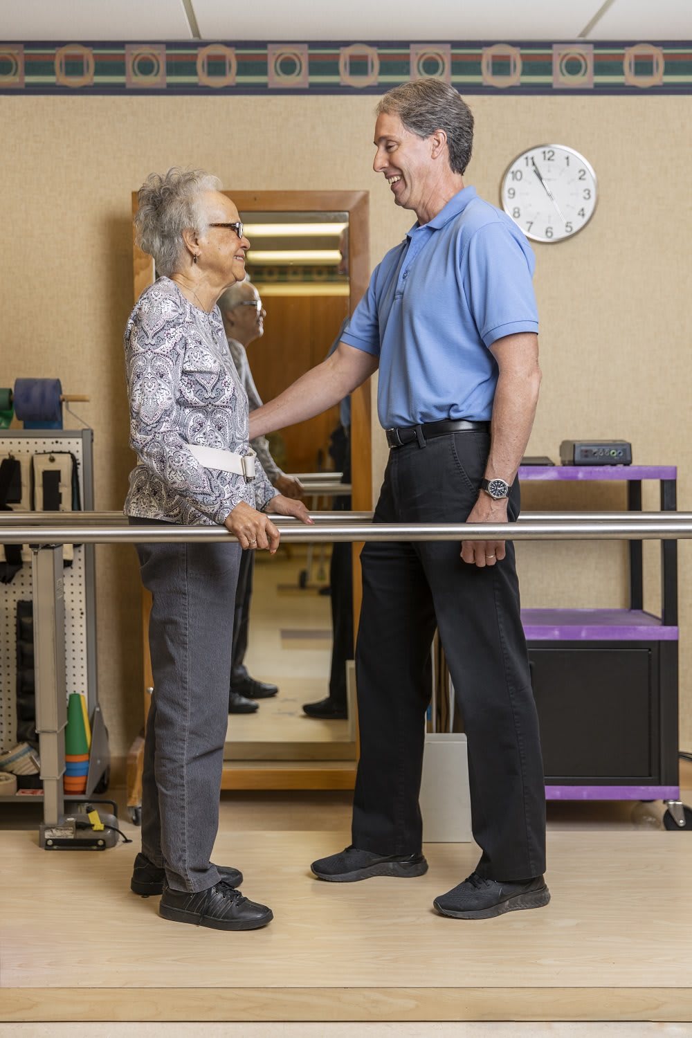 An elderly person receiving assistance from a therapist during a physical therapy session.