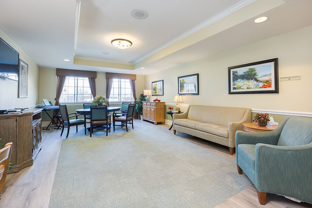 A spacious living room featuring a comfortable sofa, dining area, and elegant decor.