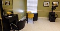 A simple office setup with a desk and chairs near a window.