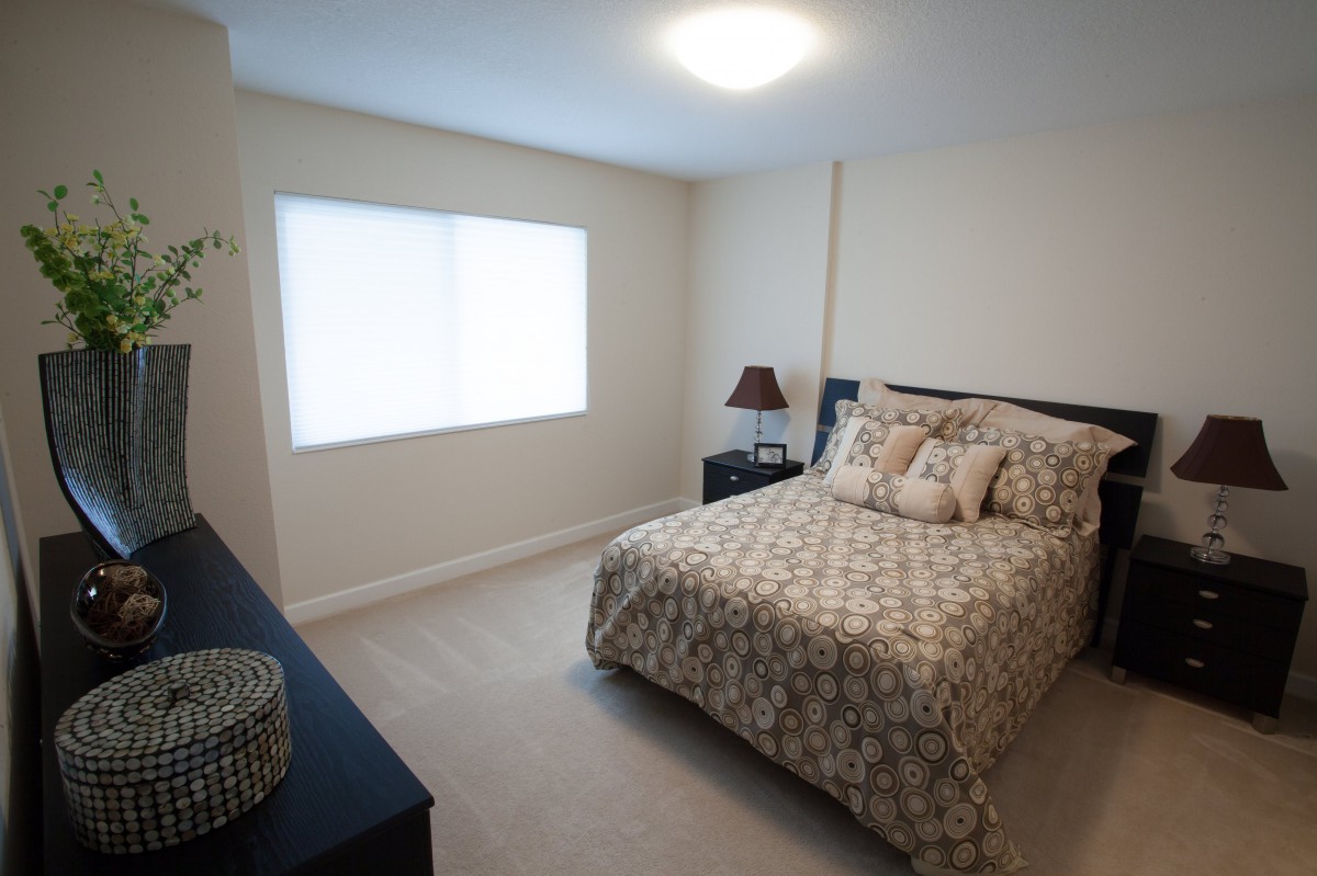 A cozy and minimalist bedroom with a comfortable bed and natural lighting.