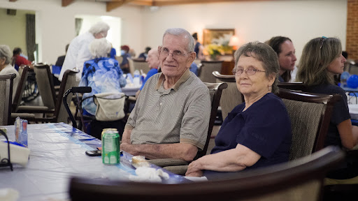 An elderly couple enjoying a moment together at a community gathering.