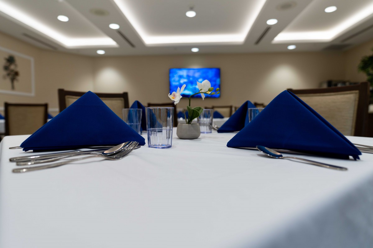 Elegant dining setup with blue napkins and modern lighting.