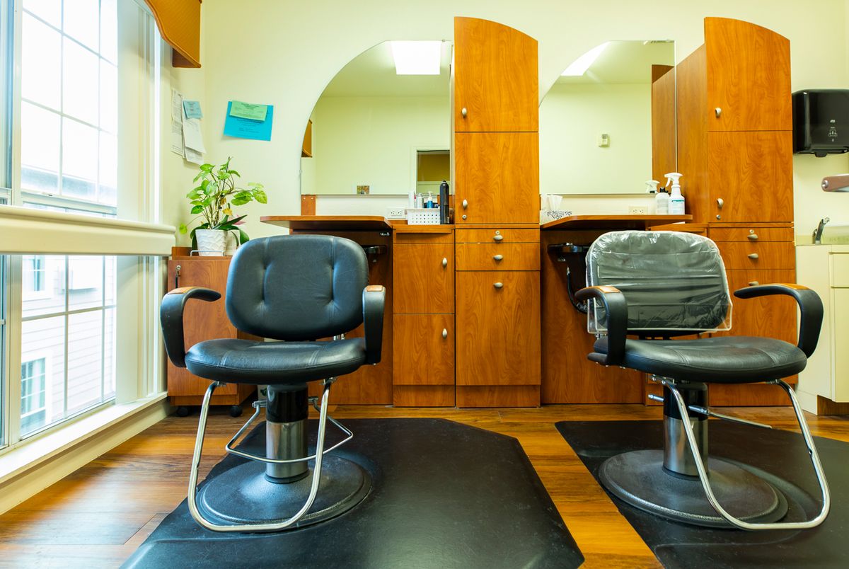 A cozy hair salon interior with two empty chairs and mirrors.