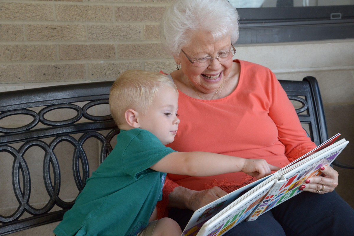 A grandmother and child enjoying a book together.