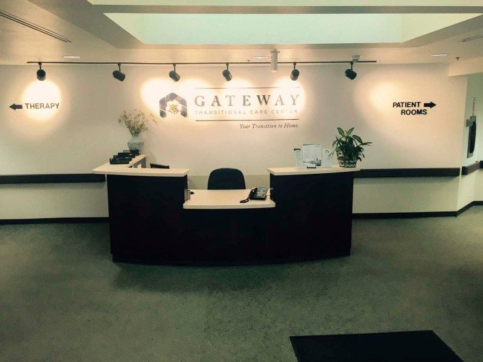 A reception area with a central desk and decorative plants.