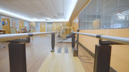 A physical therapy room featuring parallel bars for rehabilitation exercises.