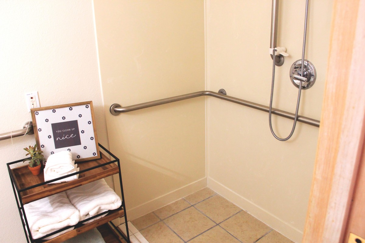 Accessible bathroom with a grab bar and towel rack.